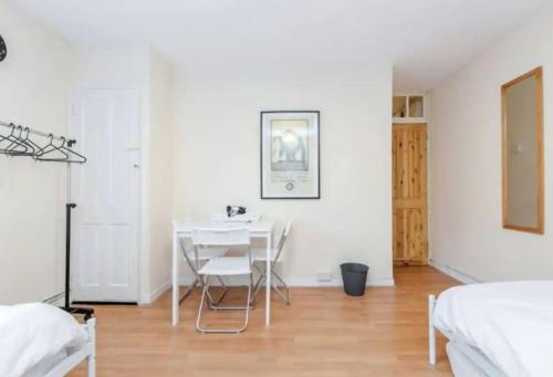 - une salle à manger blanche avec une table et des chaises blanches dans l'établissement APlaceToStay Central London apartment, Zone 1 LEIC, à Londres