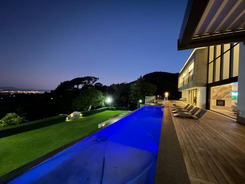 a swimming pool in front of a house at night at Camelot Villa in Cape Town