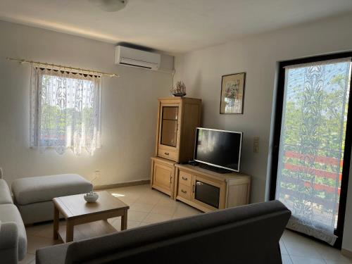 a living room with a couch and a flat screen tv at Apartmani Mikulić in Ližnjan