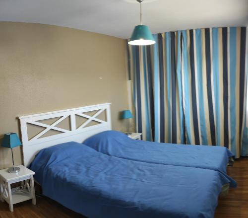 une chambre avec un lit avec une couette bleue dans l'établissement Villa duplex Soustons plage,, à Soustons