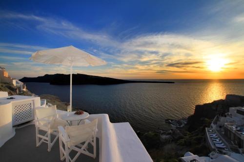 a white umbrella sitting on top of a white boat at Finesse Suites in Oia