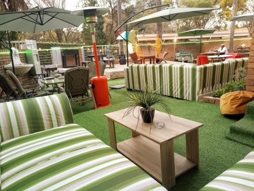 a patio with two chairs and a table and umbrella at Menlyn Mews Guesthouse in Pretoria