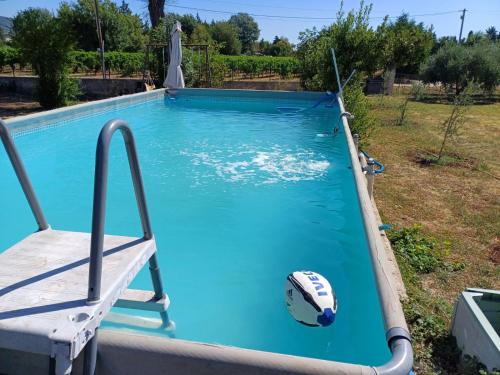 - une piscine avec une chaise et un ballon à l'eau dans l'établissement Villa au coeur des vignes, au Luc