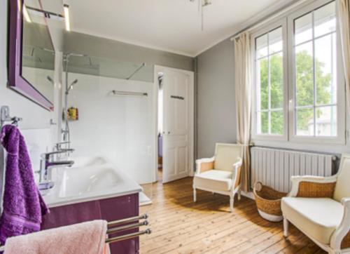 La salle de bains est pourvue d'un lavabo, d'un canapé et d'une chaise. dans l'établissement Villa sainte Adèle, à Blonville-sur-Mer