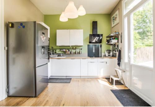  La cuisine est équipée de placards blancs et d'un réfrigérateur. dans l'établissement Villa sainte Adèle, à Blonville-sur-Mer