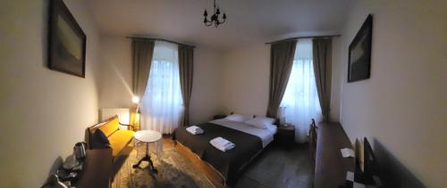 ein kleines Zimmer mit einem Bett und zwei Fenstern in der Unterkunft Zamek na wodzie w Wojnowicach in Wojnowice