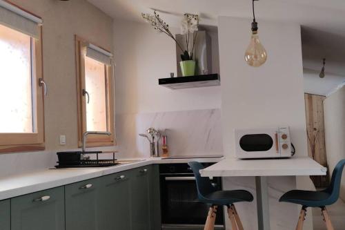 une cuisine avec deux chaises bleues et un four micro-ondes sur un comptoir dans l'établissement Tiny house cosy au cœur du Pays du Mont-Blanc, à Sallanches