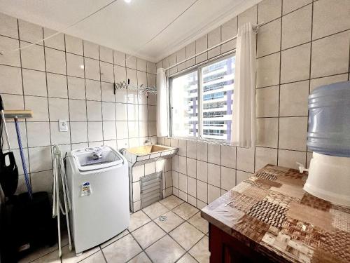 baño pequeño con fregadero y nevera en Jurere, en Meia Praia