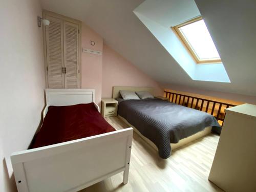 a attic bedroom with a bed and a window at Nida Loft with SPA and Tennis court in Nida