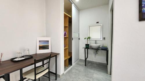 a bathroom with a desk and a sink in a room at La Palma Coliving 