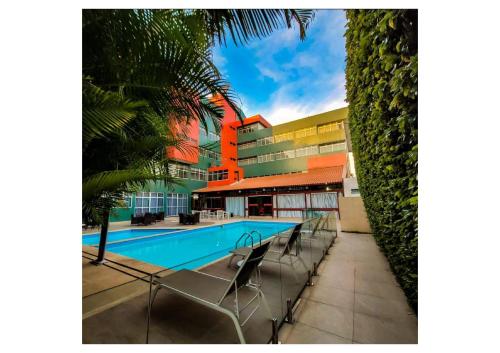 a swimming pool with chairs in front of a building at Garanhuns Palace Hotel in Garanhuns