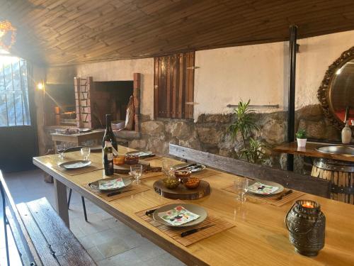 a dining room with a wooden table with wine glasses at Casa do Vale - Douro, Casa Rural de Campo com Piscina privada, 4 quartos de casal in Vilar de Maçada