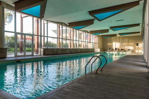 a swimming pool in a building with windows and a pooliterator at Esplendor by Wyndham Mendoza in Mendoza