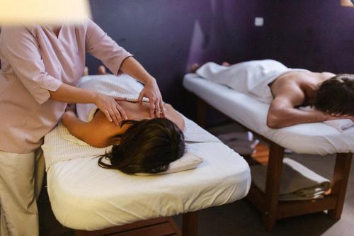 two people in beds with a woman getting a massage at Esplendor by Wyndham Mendoza in Mendoza
