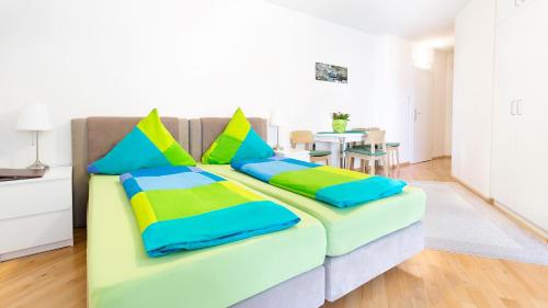 a couch with colorful pillows in a living room at Apartments an der Uniklinik in Freiburg im Breisgau