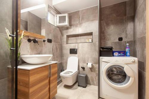 a bathroom with a washing machine and a sink at Elektra Luxury Apartment in Alexandroupoli