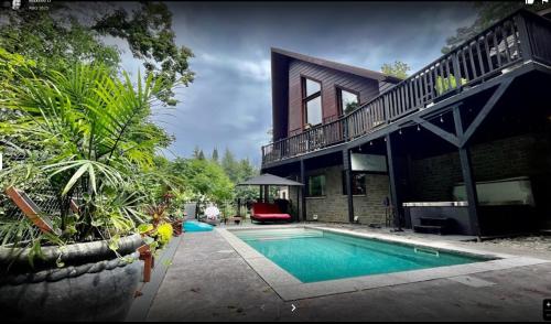 a house with a swimming pool in front of it at La Bohème - Bed & Breakfast in Bromont