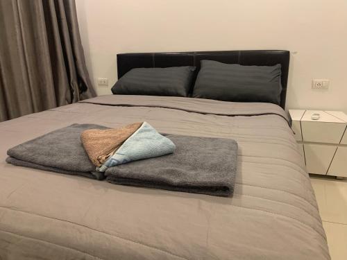 a bed with two towels sitting on top of it at Arcadia beach 网红水系公寓一房 Nice view 专业的健身房 桑拿 中心位置 交通便利 Smart tv WiFi in Pattaya South