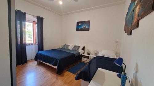 a bedroom with a bed and a table in it at Red blue with private parking and Gray blue apartment in Pula