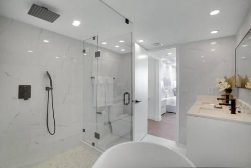 a white bathroom with a shower and a toilet at Make It Happen! Brand New with Amazing Water Views in Miami