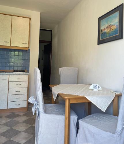 a kitchen with a table and chairs in a room at Apartmani Mikulić in Ližnjan