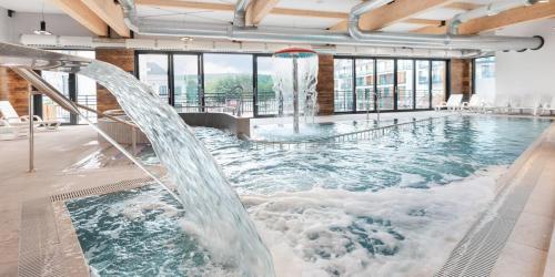 - une grande piscine avec toboggan dans un bâtiment dans l'établissement Bel Mare Resort ekskluzywny apartament dla wymagających klientów, à Międzyzdroje
