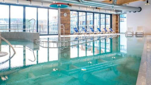 una piscina con sillas en un edificio en Bel Mare Resort ekskluzywny apartament dla wymagających klientów, en Międzyzdroje