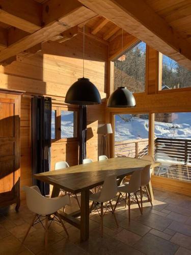 une salle à manger avec une table et des chaises en bois dans l'établissement Superbe CHALET (14 personnes) & SAUNA au pied du Mont Blanc, aux Contamines-Montjoie