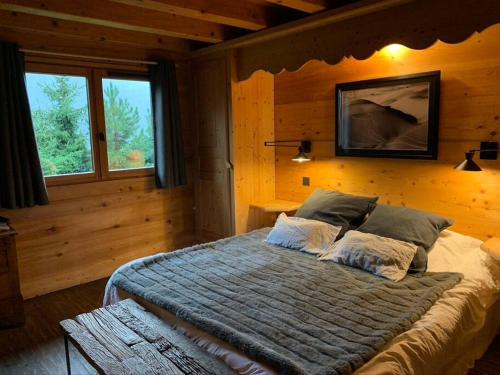 a bedroom with a large bed in a wooden room at Superbe CHALET (14 personnes) & SAUNA au pied du Mont Blanc in Les Contamines-Montjoie
