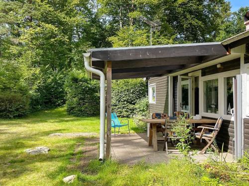 un porche de una casa con mesa y sillas en 4 person holiday home in H STVEDA en Lur