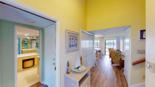 a living room with yellow walls and a table at Cozy 2BR Villa by Litchfield Beach - Heron Marsh in Pawleys Island