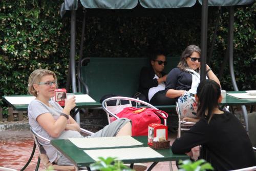 a group of people sitting at tables under an umbrella at Hotel Bogart Milano in Milan