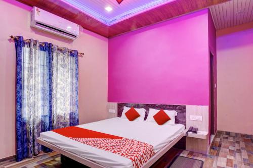 OYO Flagship 81389 Hotel Siddhi Vinayak في Motīhāri: غرفة نوم بحائط وردي وسرير