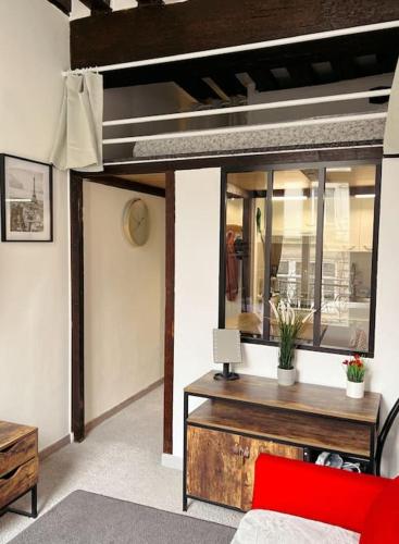Cette chambre comprend un lit et un bureau avec une chaise rouge. dans l'établissement Cosy Appart Centre de Paris, à Paris
