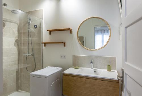 La salle de bains est pourvue de toilettes, d'un lavabo et d'un miroir. dans l'établissement Le Zandoli - Appart - Centre - Calme, à Blois