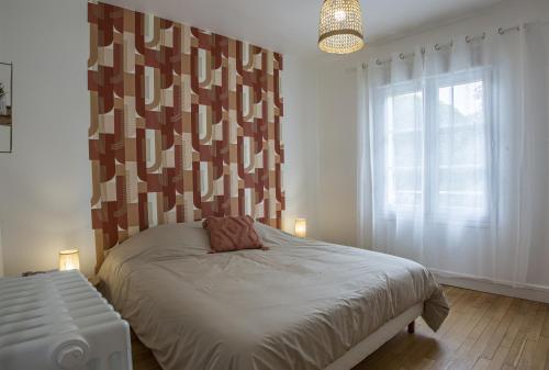 une chambre avec un lit et une grande fenêtre dans l'établissement Le Zandoli - Appart - Centre - Calme, à Blois