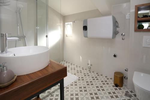 a bathroom with a large white tub and a sink at Apartments Cukovic in Herceg-Novi