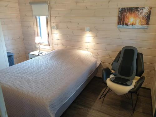 Un dormitorio con una cama y dos sillas. en Adeli Holiday Cottage Ellivuori, en Sastamala