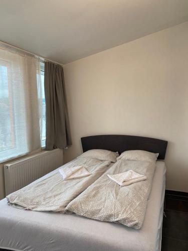 a bedroom with a bed with two napkins on it at 3 Apartments in 1 location in Prague