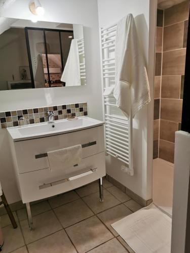 une salle de bain avec un lavabo et un miroir dans l'établissement Appartement à la campagne, à Claret