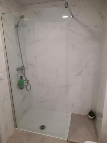 a bathroom with a shower with a white tile wall at Almar Relax in Daimuz