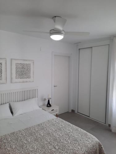 a white bedroom with a bed and a window at Almar Relax in Daimuz