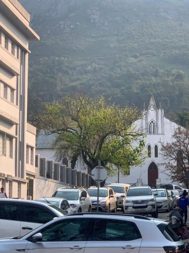 a parking lot with cars parked in front of a church at Kaneel Suiker in Paarl