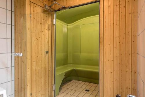 a bathroom with a shower with a green tub at Studio centralissimo a St. Moritz in St. Moritz