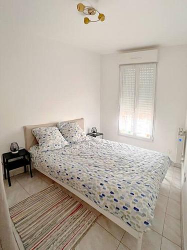 une chambre blanche avec un lit et une fenêtre dans l'établissement Cosy Appart. aux portes de Paris, à Villejuif