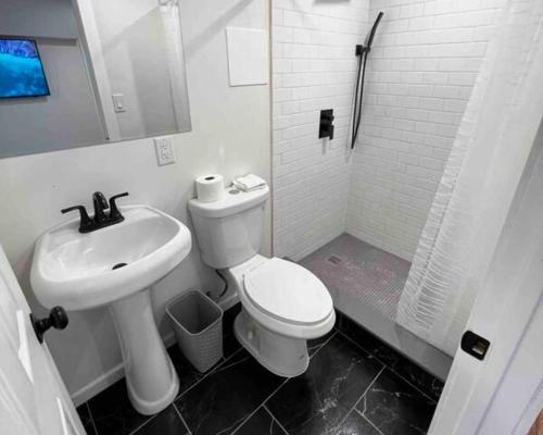 a bathroom with a white toilet and a sink at Modern Studio in Norwalk in Norwalk
