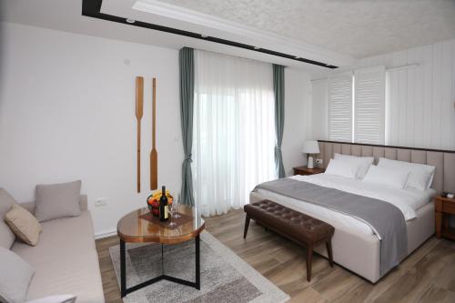 a bedroom with a bed and a couch and a table at Apartments Cukovic in Herceg-Novi