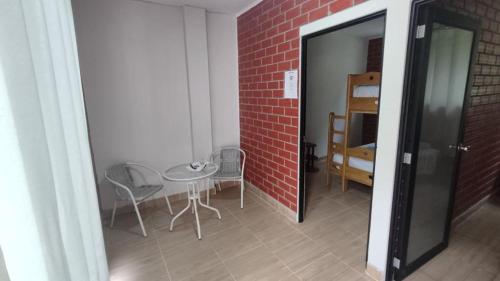 Las Palmas的住宿－Bello Amanecer，一间设有椅子和桌子的房间和砖墙