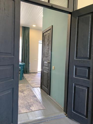an empty room with a door and a mirror at DendroBak GuestHouse in Stepʼanavan