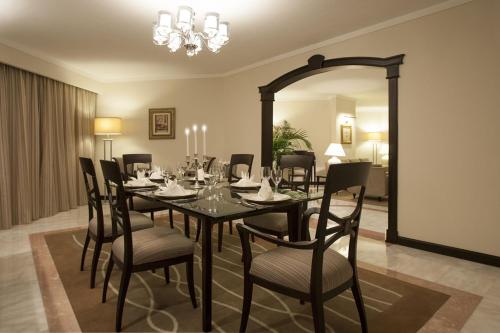 a dining room with a table and chairs and a mirror at Danat Al Ain Resort in Al Ain
